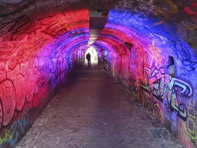 902067 Gezicht in het wed aan de Oudegracht te Utrecht, vanaf de Ganzenmarkt. De tunnel vol graffiti wordt in ...